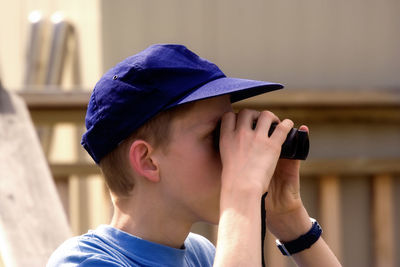 Close-up of teenage boy looking through binoculars