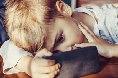 Close-up of boy using mobile phone.