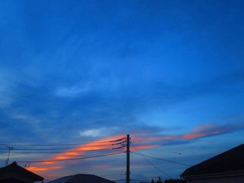 Low angle view of silhouette electricity pylon against sky