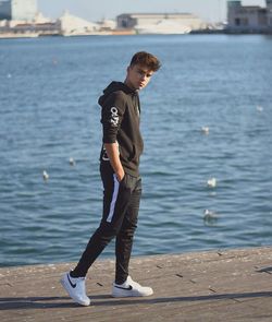 Full length of young man standing in sea