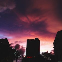 Low angle view of buildings against cloudy sky