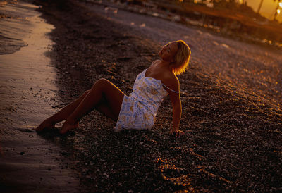 Full length of young woman standing at beach