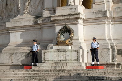 Statue of woman standing in front of historical building