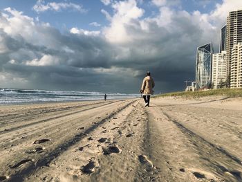 Rear view of man walking on beach