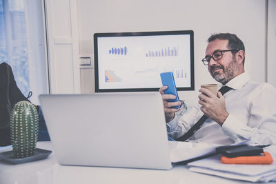 Business man works with laptop sitting at the desk. male at computer work online with remote office