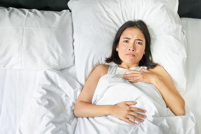 Portrait of young woman sleeping on bed at home