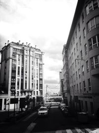 Buildings in city against cloudy sky