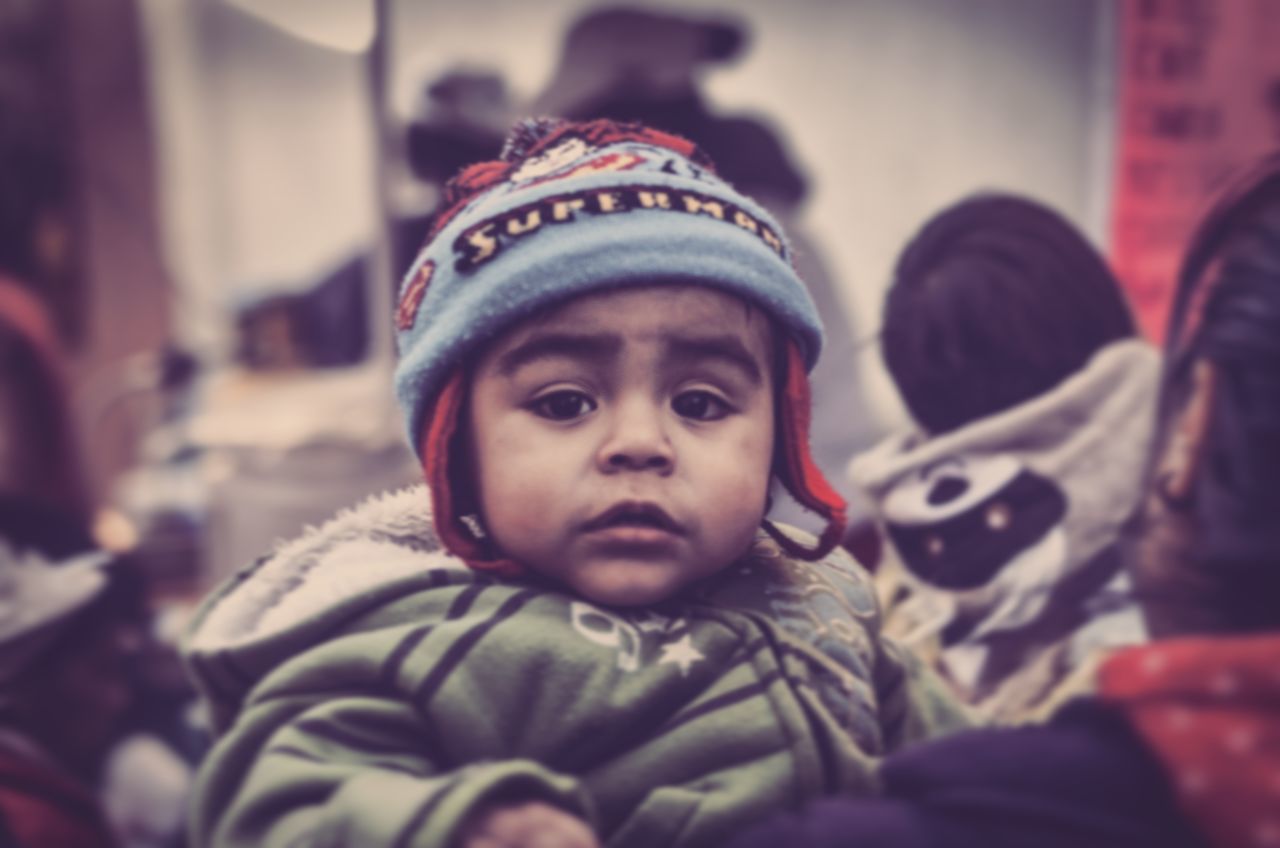 lifestyles, portrait, looking at camera, indoors, person, leisure activity, focus on foreground, front view, casual clothing, headshot, smiling, childhood, selective focus, warm clothing, close-up, happiness, boys