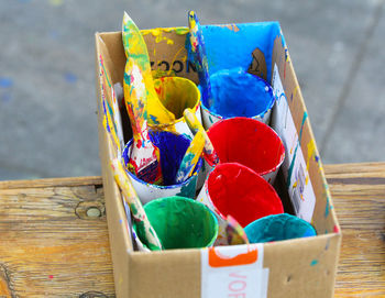 High angle view of multi colored paint containers on table