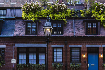 Red brick wall apartment buildings with flowers at window and lanterns