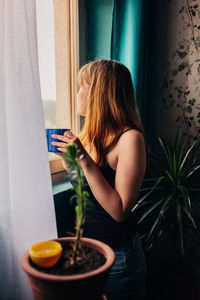 Woman sitting by window at home