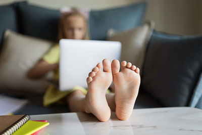 Midsection of child holding smart phone on table