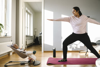 Mother with baby exercising in living room