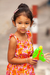 Portrait of cute girl playing with squirt gun