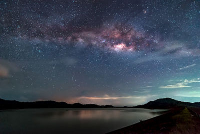 Scenic view of lake against sky at night