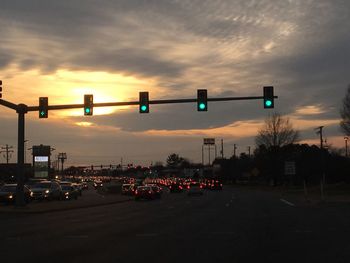 Road signal against sky during sunset