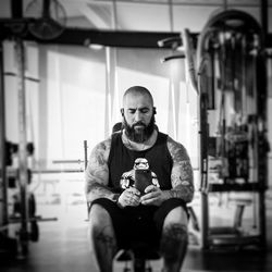 Mature man taking selfie while sitting in gym