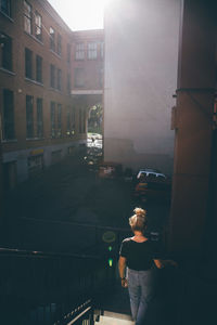 Rear view of young woman on walking on steps in city