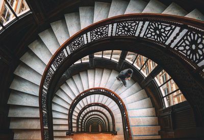 High angle view of man climbing up on staircase in building