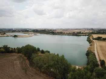 High angle view of river amidst trees against sky