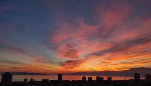 Silhouette buildings against sky during sunset