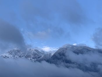 Low angle view of snowcapped mountains against sky