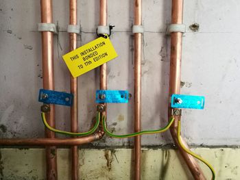 Close-up of pipes attached on wall in factory