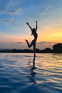 Silhouette woman jumping in sea