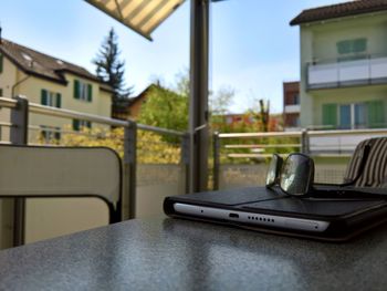 Close-up of laptop on table against buildings