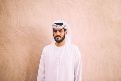 Portrait of man standing against wall