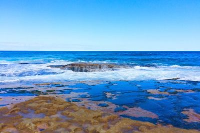 Scenic view of sea against clear blue sky