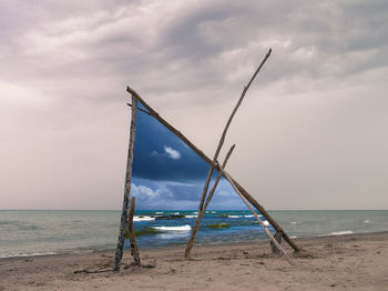 Lifeguard hut on beach against sky