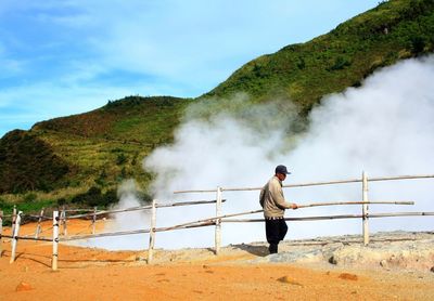 Man standing on mountain against sky