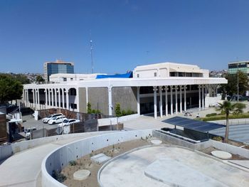 Buildings by swimming pool against clear blue sky