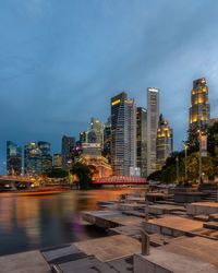 Illuminated modern buildings in city against sky