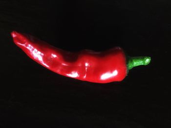 Close-up of red rose over black background