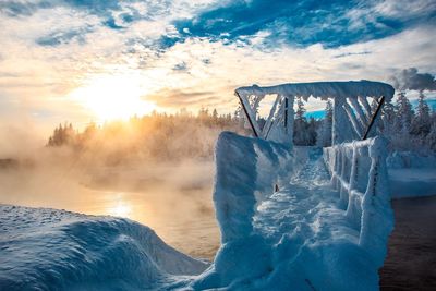 Scenic view of frozen lake against sky during sunset