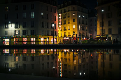 Reflection of illuminated buildings in city at night