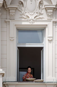 Portrait of man sitting by window at home