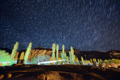 Scenic view of illuminated land against sky at night