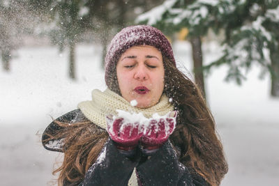 Close-up of woman blowing snow