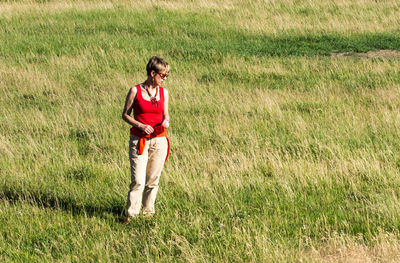 Full length portrait of a smiling young man standing on field