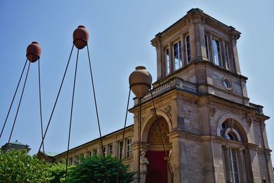 Low angle view of street light by building against sky