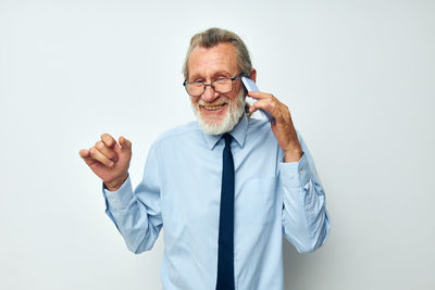 Portrait of young man standing against white background