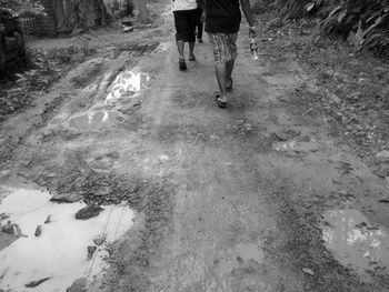 Low section of people walking on wet muddy road during indian monsoon season