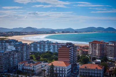 High angle view of city by sea against sky