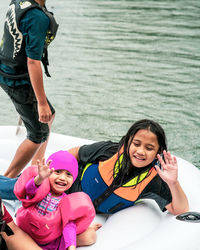 Children wearing life jackets paddling on an inflatable boat in kenyir lake, malaysia.