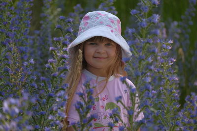 Portrait of smiling girl standing amidst purple flowers