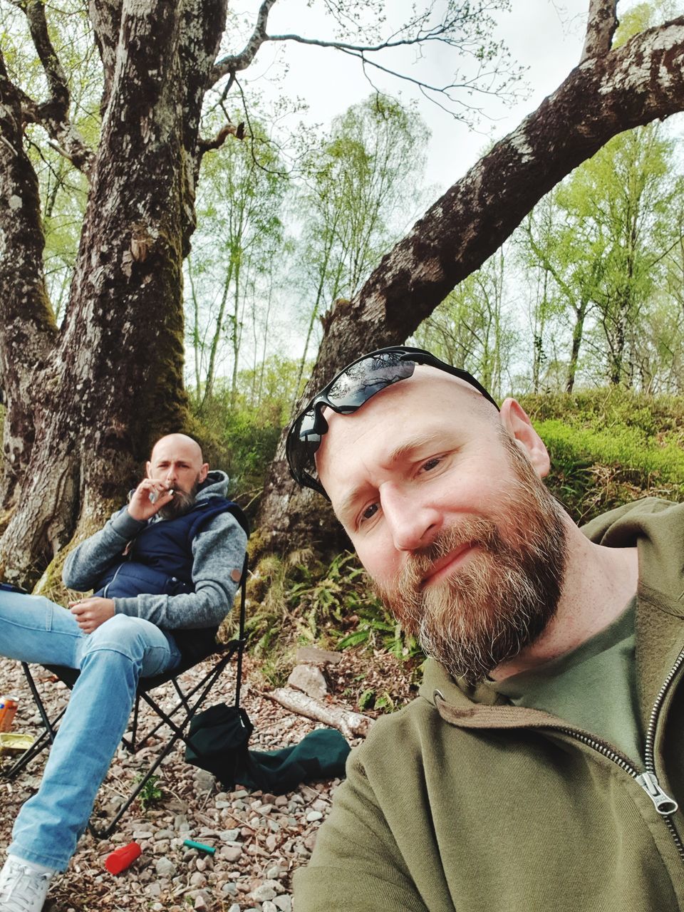 tree, plant, men, males, real people, sitting, mid adult, leisure activity, mid adult men, facial hair, lifestyles, adult, beard, forest, casual clothing, nature, smiling, people, young men, mature men, mature adult, outdoors