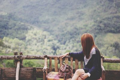 Woman sitting against mountains